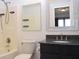 Bathroom with a shower-tub combo, toilet, and vanity with black granite countertop and framed mirror at 400 Lockerbie Ln, Pittsboro, IN 46167