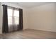Light-filled bedroom showcasing neutral walls, wood floors, and window with decorative curtains for comfort at 400 Lockerbie Ln, Pittsboro, IN 46167