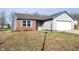 Home exterior features a brick accent, vinyl siding, an attached two-car garage, and a well-maintained front lawn at 400 Lockerbie Ln, Pittsboro, IN 46167