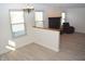 Spacious living room featuring wood floors, large windows, and a cozy brick fireplace, ideal for relaxation at 400 Lockerbie Ln, Pittsboro, IN 46167