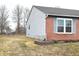 Side view of a single-Gathering home with brick accents, vinyl siding, and a well-maintained lawn at 400 Lockerbie Ln, Pittsboro, IN 46167