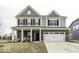 Charming two-story home featuring a brick facade, attached two-car garage and covered porch with seating area at 4078 Omaha Dr, Bargersville, IN 46106