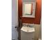Charming bathroom featuring a pedestal sink with white vanity and a decorative mirror at 410 N Euclid Ave, Indianapolis, IN 46201