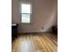 Bright bedroom with hardwood floors, a window letting in natural light, and pink walls at 410 N Euclid Ave, Indianapolis, IN 46201
