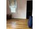 A bedroom features hardwood floors, a window with a curtain, and pink walls at 410 N Euclid Ave, Indianapolis, IN 46201