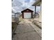View of a detached garage with a white door and a cracked driveway at 410 N Euclid Ave, Indianapolis, IN 46201
