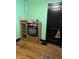 This room includes a cabinet with an old television, hardwood floors, and green walls at 410 N Euclid Ave, Indianapolis, IN 46201