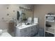 Bathroom featuring a dual sink vanity, a large mirror, and a storage shelf at 4418 Tarragon Dr, Indianapolis, IN 46237