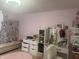 Bedroom with pink walls, decorative wall hangings, and furniture at 4418 Tarragon Dr, Indianapolis, IN 46237