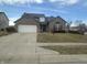 Charming two-story brick home featuring an attached two-car garage and neatly maintained front lawn at 4418 Tarragon Dr, Indianapolis, IN 46237