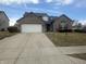 Charming two-story brick home featuring an attached two-car garage and neatly maintained front lawn at 4418 Tarragon Dr, Indianapolis, IN 46237