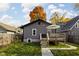View of a charming gray home showcasing a wooden deck and grassy backyard at 4818 Guilford Ave, Indianapolis, IN 46205