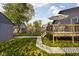 Backyard featuring deck, detached garage, and grassy yard with sidewalk at 4818 Guilford Ave, Indianapolis, IN 46205