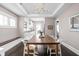 Open dining room features a wooden table, modern lighting, and flows into the stylish white kitchen at 4818 Guilford Ave, Indianapolis, IN 46205