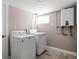 Bright laundry room with a washer, dryer and tankless hot water heater at 4818 Guilford Ave, Indianapolis, IN 46205