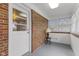 Cozy sunroom featuring brick accent walls, windows and an illuminated entryway with a lamp and bright overhead lighting at 488 N 24Th Ave, Beech Grove, IN 46107