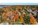 Aerial view of a neighborhood surrounded by colorful fall foliage, showcasing houses near a body of water at 5015 Watersite Cir, Indianapolis, IN 46254