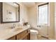 Cozy powder room with decorative wallpaper, a wooden vanity, and a framed mirror at 5015 Watersite Cir, Indianapolis, IN 46254
