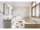 Bathroom with double sinks, tub, and natural light from the window at 5015 Watersite Cir, Indianapolis, IN 46254
