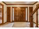 Elegant foyer featuring tile flooring, wood trim, a staircase and glass paneled doors at 5015 Watersite Cir, Indianapolis, IN 46254