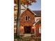 Close up of a brick home's entrance with a wooden front door and autumn leaves on the ground at 5015 Watersite Cir, Indianapolis, IN 46254