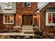Inviting front entrance with brick accents, a wooden door, and well-maintained landscaping and fall foliage at 5015 Watersite Cir, Indianapolis, IN 46254