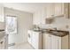 Bright laundry room featuring white cabinetry, modern appliances, and a sink at 5015 Watersite Cir, Indianapolis, IN 46254