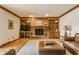 Well-lit living room with a brick fireplace, built-in shelves, and hardwood floors at 5015 Watersite Cir, Indianapolis, IN 46254