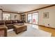 Comfortable living room features a large leather sectional sofa, ottoman, and sliding glass doors to the screened porch at 5015 Watersite Cir, Indianapolis, IN 46254
