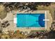 Aerial view of a rectangular pool with a diving board and ladders surrounded by a concrete patio and greenery at 5015 Watersite Cir, Indianapolis, IN 46254