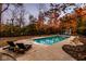Inviting in-ground pool surrounded by a concrete patio, with lounge chairs, set amid vibrant autumn foliage at 5015 Watersite Cir, Indianapolis, IN 46254