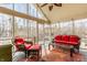Bright sunroom with wicker furniture and a view of the wooded backyard at 5015 Watersite Cir, Indianapolis, IN 46254