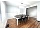 Bright dining room features wainscoting, hardwood floors, and a modern light fixture at 504 S Main St, Waldron, IN 46182