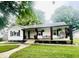 Charming home featuring a covered front porch with stylish seating and beautifully landscaped front yard at 504 S Main St, Waldron, IN 46182