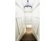 Elegant staircase with decorative molding, leading to a lower level, illuminated by a modern light fixture at 504 S Main St, Waldron, IN 46182