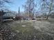 View of a home with a covered back porch, large yard, and various trees at 5202 Riverview Dr, Indianapolis, IN 46208