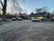 View of the exterior of a home with a detached garage and multiple vehicles in the driveway at 5202 Riverview Dr, Indianapolis, IN 46208
