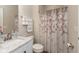 Bathroom with white marble vanity, matching toilet, shower with flower pattern curtain, and towel rack at 5344 Misthaven Ln, Greenwood, IN 46143