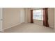 Neutral bedroom with a white door, large window with curtains, and neutral carpet at 5344 Misthaven Ln, Greenwood, IN 46143