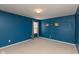 This bedroom has a blue wall, neutral carpet, and a window with patterned curtains at 5344 Misthaven Ln, Greenwood, IN 46143