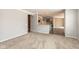 Open-concept living area with neutral carpet and paint, connecting to the kitchen with gray cabinets at 5344 Misthaven Ln, Greenwood, IN 46143