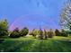 Lush green backyard under a beautiful rainbow, offering a serene and picturesque view at 5769 Marsh Glen Ct, Carmel, IN 46033