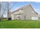 Backyard with patio, green grass, mature trees, and an attached two-car garage at 5769 Marsh Glen Ct, Carmel, IN 46033