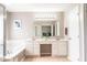 Bright bathroom with double sink vanity, bathtub, shower, and large mirror at 5769 Marsh Glen Ct, Carmel, IN 46033