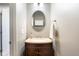 Powder room featuring a vanity with granite countertop, oval mirror, and decorative fixtures at 5769 Marsh Glen Ct, Carmel, IN 46033