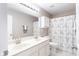 Bright bathroom featuring a double sink vanity, large mirror, and decorative shower curtain at 5769 Marsh Glen Ct, Carmel, IN 46033