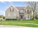 Charming two-story brick home featuring well-maintained landscaping and a beautiful, blossoming tree in the front yard at 5769 Marsh Glen Ct, Carmel, IN 46033