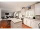 Open kitchen featuring white cabinetry, stainless steel appliances, and an island with seating, flowing into the living area at 5769 Marsh Glen Ct, Carmel, IN 46033