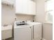 Well-lit laundry room includes modern washer, dryer, utility sink and storage cabinets at 5769 Marsh Glen Ct, Carmel, IN 46033