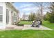 Backyard patio with dining set, grill, manicured lawn, and landscaping at 5769 Marsh Glen Ct, Carmel, IN 46033